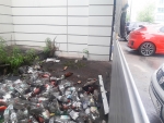 Свалка бытового мусора за гаражными жалюзями в доме №55 по улице Ленина рядом с продуктовым магазином «ВкусВилл».